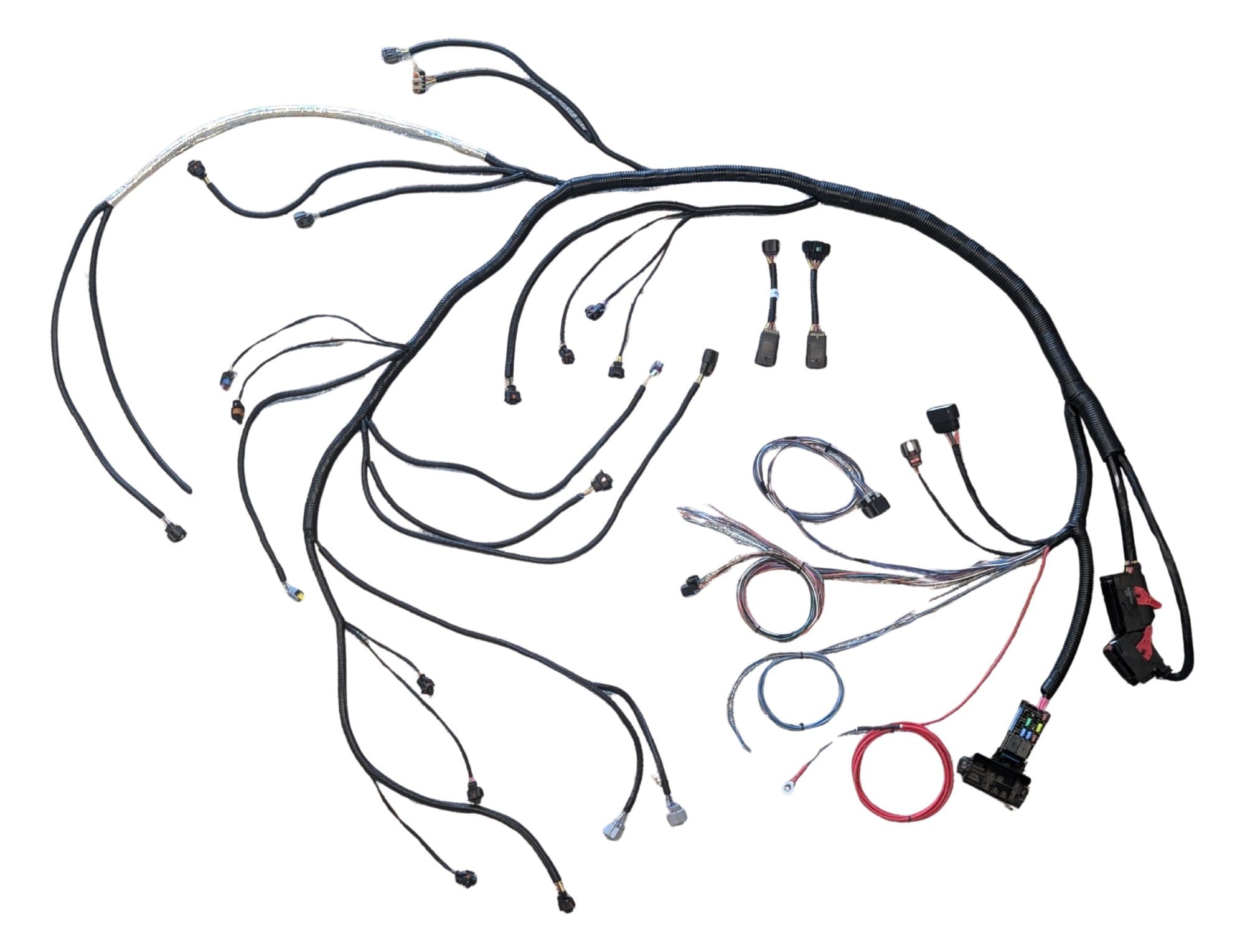All new one piece standalone Duramax ECM and engine harness laid out with its connectors, fuse and relay block, and pigtails